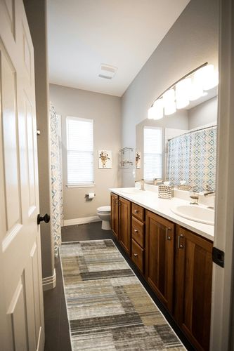 HomeRoots 8' Beige Charcoal Brown Grey Tan Gold and Blue Geometric Power Loom Runner Rug with Fringe in Wooden and Grey Bathroom