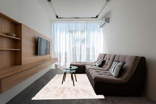 6' x 9' Ivory fluffy rug in Grey Living Room with Brown Couch