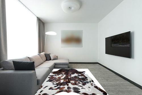 Sunshine Cowhides Genuine Tricolor Spotted Cowhide Rug - Luxurious Cow Rug for Bedroom, Living Room, and Home Decor Enthusiasts - Masterpiece of Style and Functionality - 6x6-7ft (180x210cm) in Modern Living Room with Grey Couch