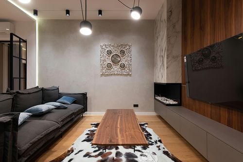 Sunshine Cowhides Genuine Tricolor Brindle Cowhide Rug - Luxurious Cow Rug for Bedroom, Living Room, and Home Decor Enthusiasts - Masterpiece of Style and Functionality - XL 6x7-8ft (180x240cm) in Dark Wood Living Room with Black Couch
