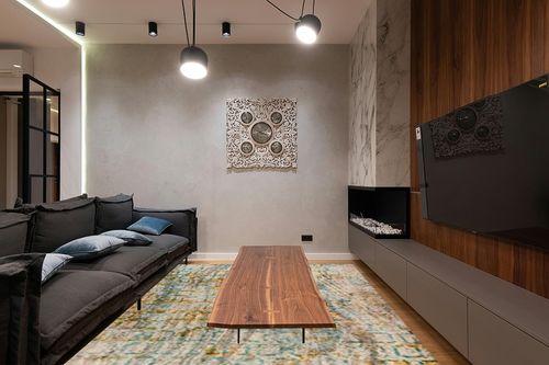 Mat The Basics Torrance Area Rug (9' x 12', Aqua/Orange) in Dark Wood Living Room with Black Couch