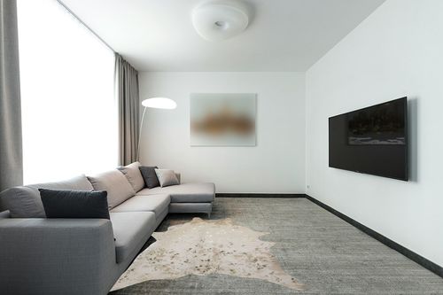 LAKKH Fourtue 4.2x6ft Faux Cowhide Rug - Synthetic Cow Hide Rug - Cowhide Rug Faux - Cowhide Rugs for Living Room Bedroom & Home Office - Plush Synthetic Fur w/ Soft Backing (Gold & Cream) (L-02) in Modern Living Room with Grey Couch