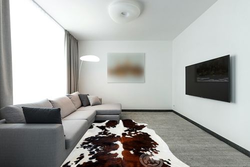 Sunshine Cowhides Genuine Tricolor Cowhide Rug - Luxurious Cow Rug for Bedroom, Living Room, and Home Decor Enthusiasts - Masterpiece of Style and Functionality - XL 6x7-8ft (180x220cm) in Modern Living Room with Grey Couch