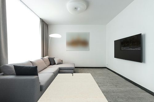 Brockton Solid Wool Modern Farmhouse Area Rug - Suitable for Living Room Bedroom -%100 Wool - Single Color - Hand Loomed - Medium Pile - Beige, Cream - 5' x 8' in Modern Living Room with Grey Couch